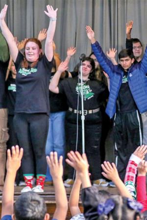 singers on stage with their hands up